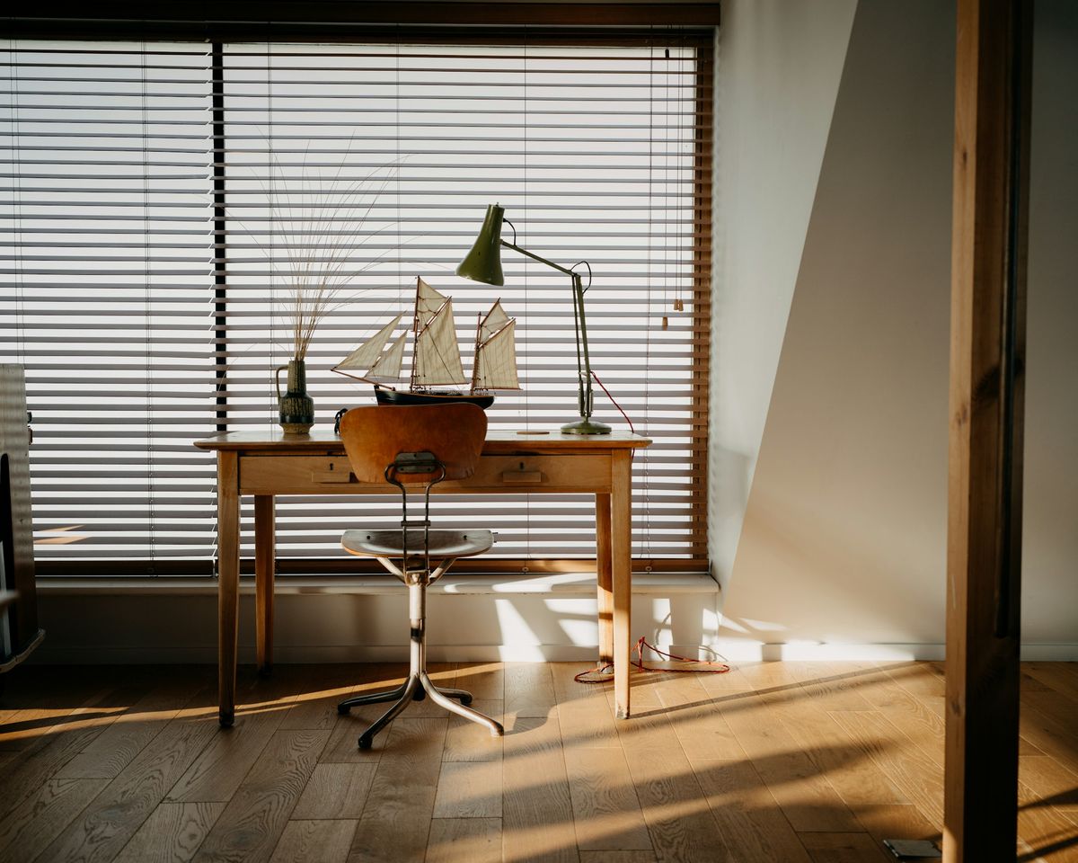 A wooden desk by a window in natural light